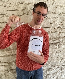 A photo of Christopher holding a jar. The label on the jar says 'Labels are for jars, not people!' 