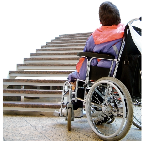 Photo of a person who is a wheelchair user in front of a set of stairs